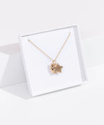 Quarter view of gold vermeil finish of the Pusheen Celestial Charm Necklace in its white packaging box. 
