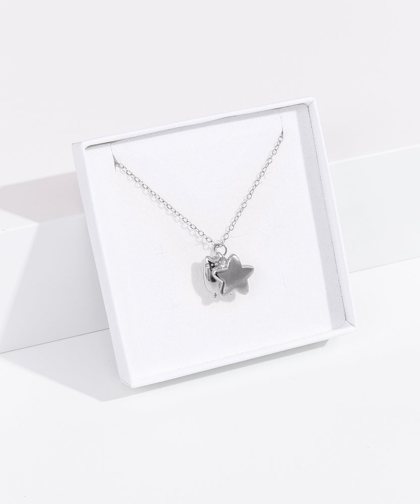 Front quarter view of the sterling silver finish of the Pusheen Celestial Charm Necklace in its white packaging box. 