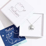 Sterling silver finish of Pusheen Charm Necklace in its packaging. The necklace is placed inside a white box with a blue informational card.  