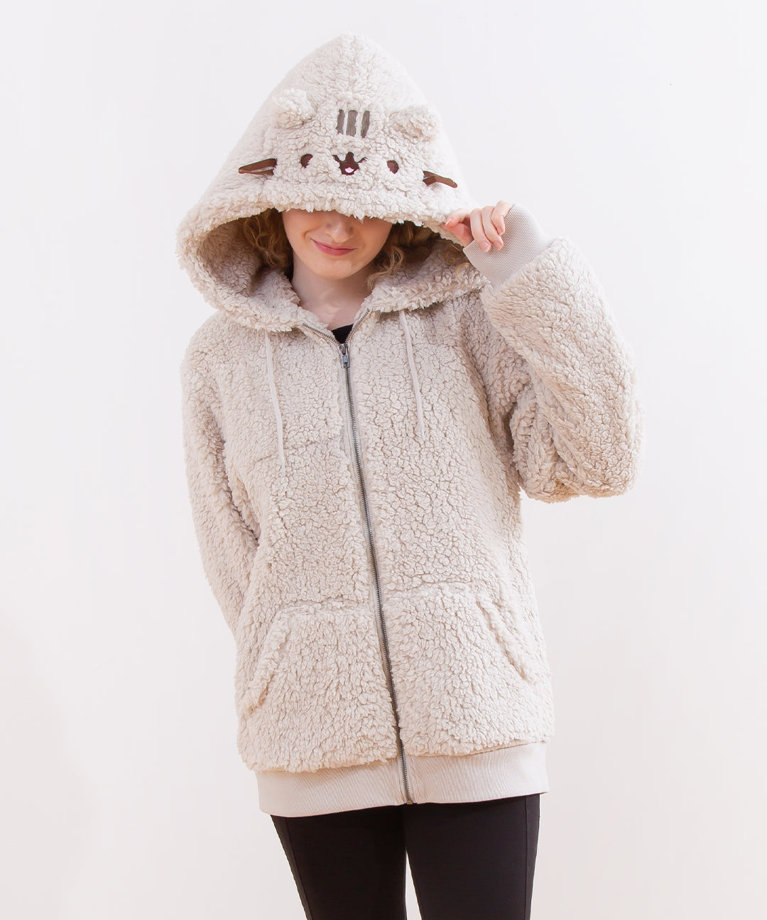 Model wearing the Pusheen Character hoodie, pulling the hood over their eyes to showcase Pusheen's face on the hood. The hoodie takes on a cone shape, and the hoodie is slightly baggy.