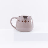 The Pusheen Character Mug resting on top of a white pedestal in front of a white background.