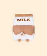 Back view of the Chocolate Milk Sips Plush. The back of the plush features the word ‘Milk’ in brown embroidery, plush back paws, and an extended white and brown striped tail. 