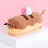 Left quarter view of dessert inspired plush. This view shows Pusheen’s long cylinder body and two-toned color details. The top of the plush is light brown to imitate chocolate drizzle.