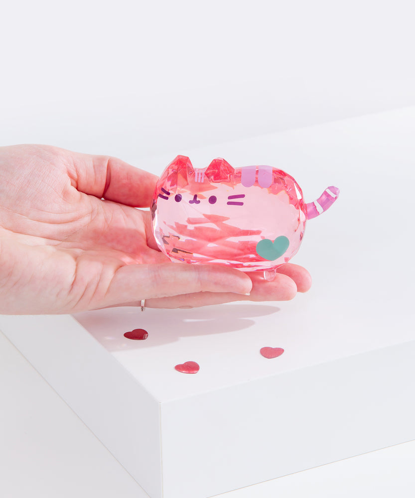 Model holds the light pink cat figurine to show the scale of acrylic Facets.  