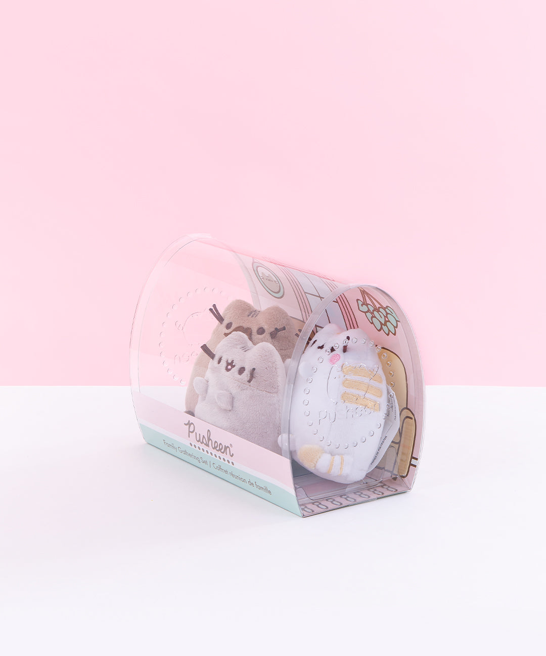 Quarter view of the mini plush in the packaging facing the left in front of a light pink background.