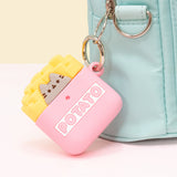 Pusheen French Fries Airpods Case clipped to a mint green backpack. The pink case features Pusheen the Cat in her classic form as a grey cat with black eyes, whiskers, and nose. The cat sits in a pink fry container with the word Potato highlighted in white with yellow french fries coming out of the container. 