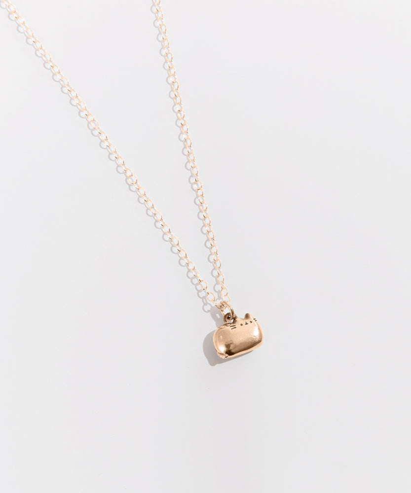 The gold charm necklace on top of a white background.