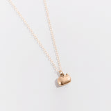 The gold charm necklace on top of a white background.