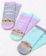 All three sock sets lay on a white fluffy surface with a ray of sunshine shining on the socks to enhance the vivid colors.  