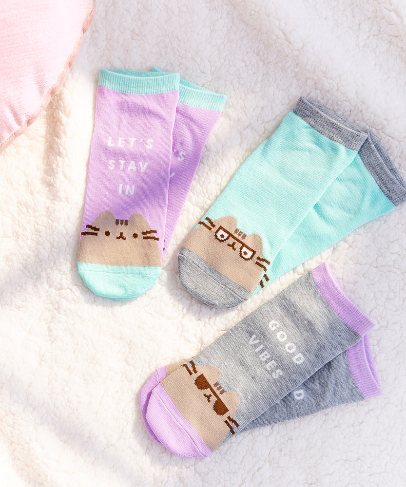 All three sock sets lay on a white fluffy surface with a ray of sunshine shining on the socks to enhance the vivid colors.  