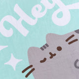Close-up of the center graphic of the Hey Throw Blanket. The printed graphic shows Pusheen in her classic grey and brown colors with the phrase “hey” printed above in white.