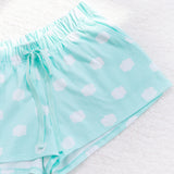 A close-up view of the mint green drawstring pajama shorts. The adjustable ribbon matches the color of the light mint green short. The shorts have an overall pattern of white fluffy clouds. 