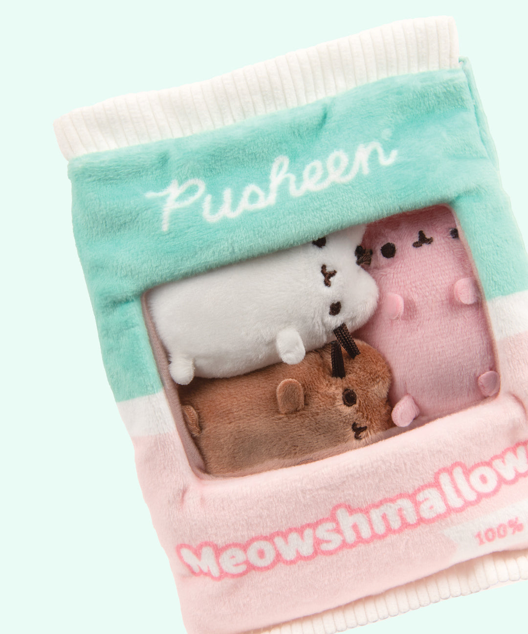 Close-up view of the miniature plush inside the Meowshmallows bag. The white top and bottom edges of the bag have a crinkled look to imitate a bag closure. 