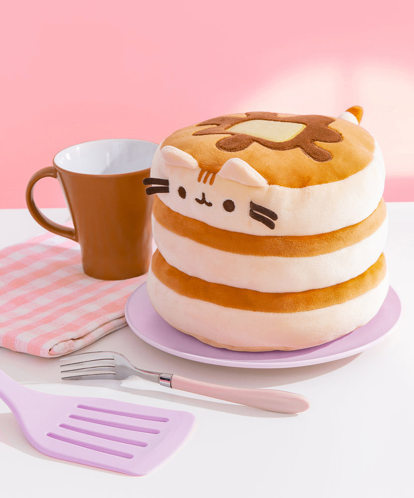 Right quarter view of the Pusheen Pancake Squisheen. Pusheen's cream-colored ears sit at the top edge of the pancake stack and three light brown stripes sit between her ears. 