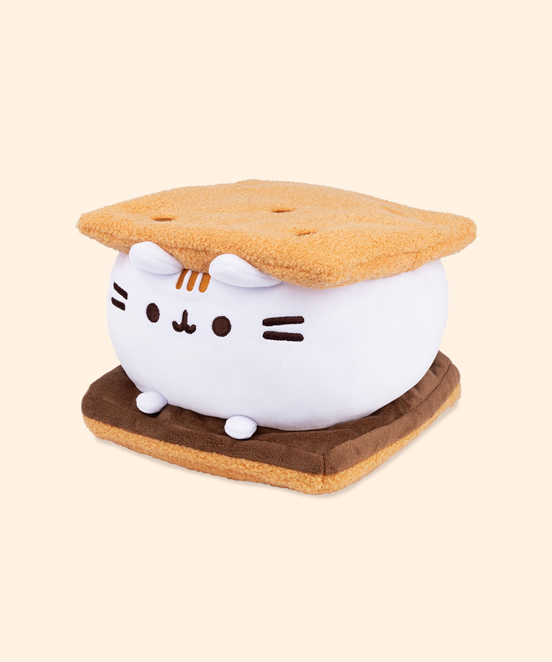 Left quarter view of s’mores-inspired plush. This view shows Pusheen’s white marshmallow feet extending off her body resting atop the chocolate slab.  