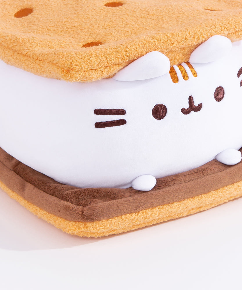 Close-up view of Pusheen S'mores Squisheen.This view shows Pusheen’s white marshmallow feet extending off her body resting atop the chocolate slab.