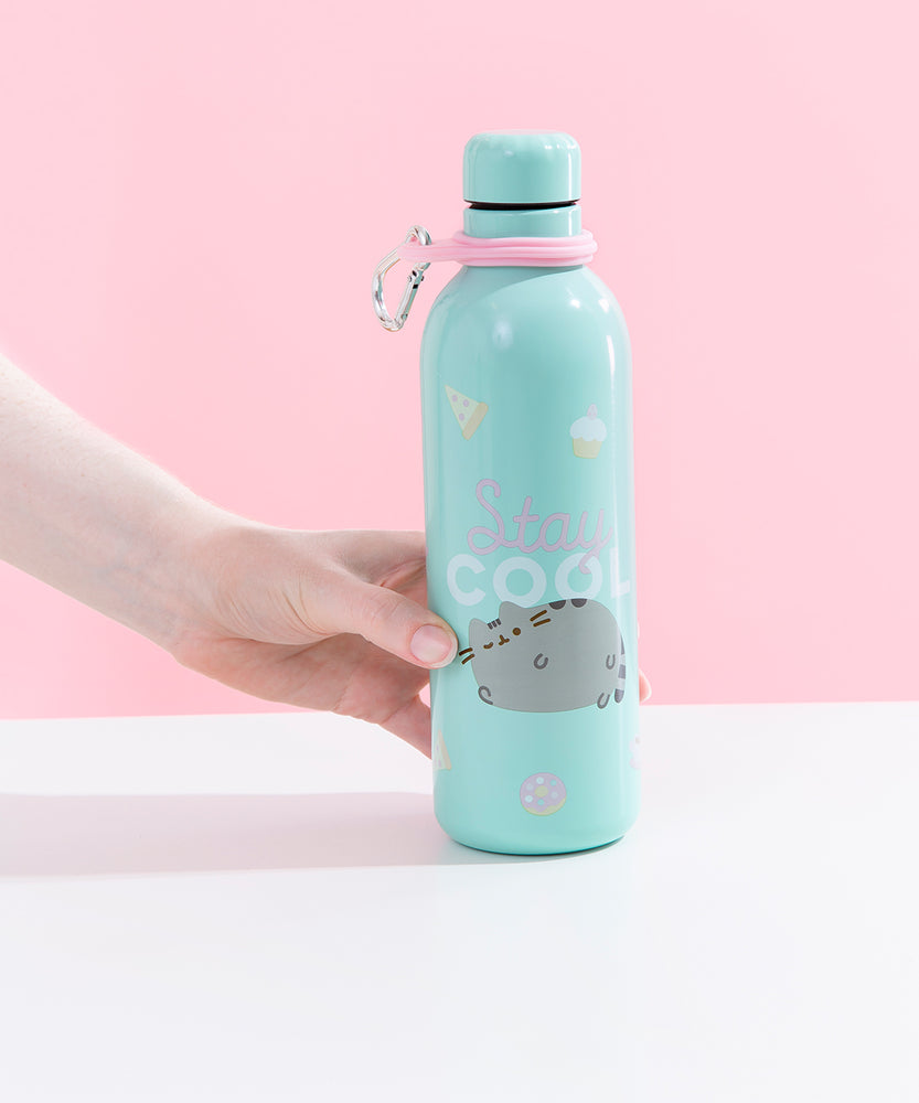 A model’s hand holding the Pusheen Stainless Steel Waterbottle on top of a white and pink background.