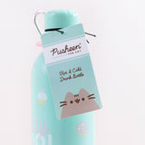 Close up of the hangtag hanging from the Pusheen Stainless Steel Waterbottle. The tag is a similar light blue as the bottle, with the Pusheen logo in a white rectangle near the top, Pusheen at the bottom, and the text ‘Hot and Cold Drink Bottle’ written in cursive in the middle.