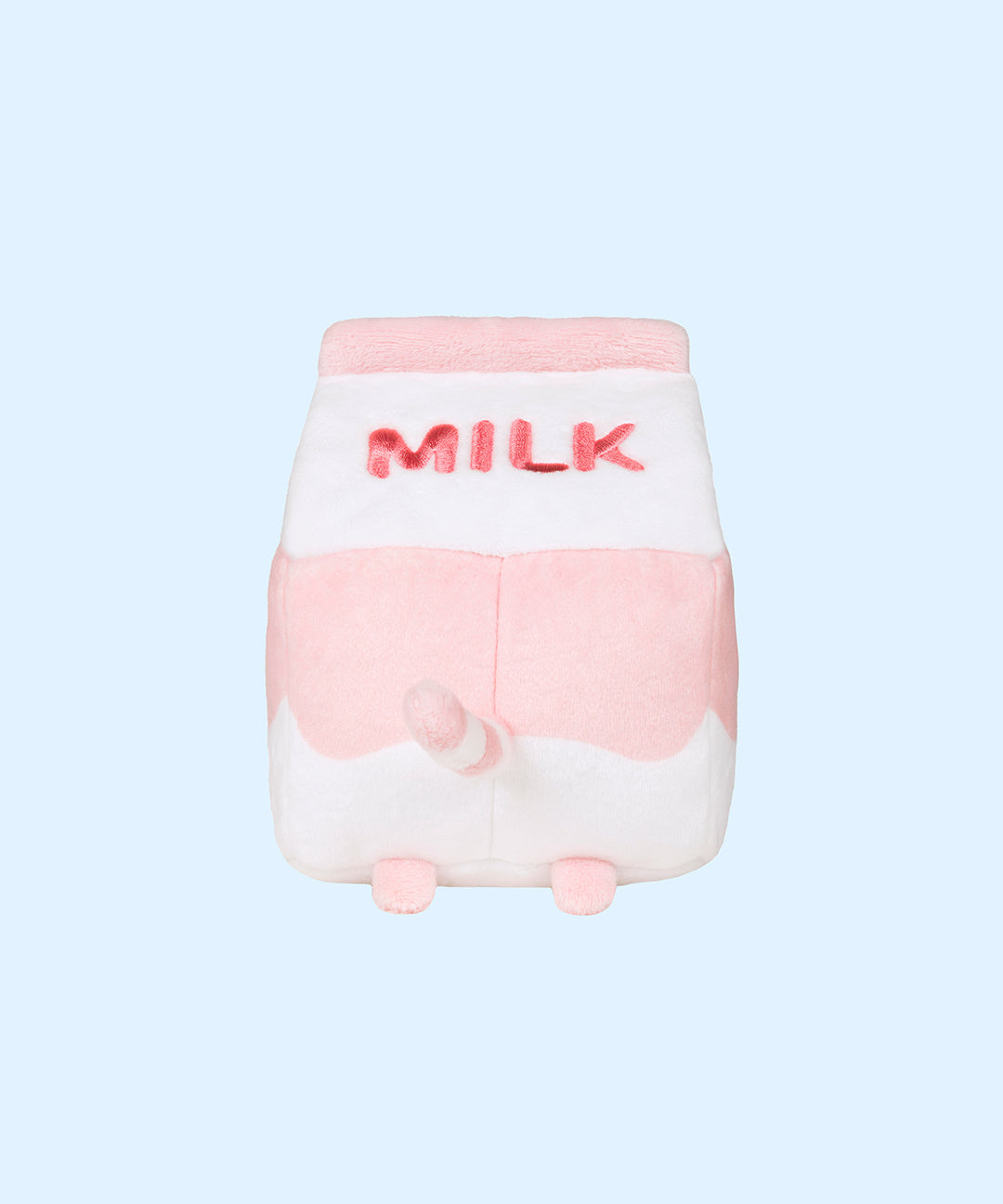 The back view of the Juice Box Sips Plush shows off pink ‘Milk’ embroidery, pink feet, and white and pink striped tail that extends slightly off the body of the carton-shaped plush. 