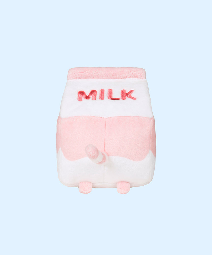 The back view of the Juice Box Sips Plush shows off pink ‘Milk’ embroidery, pink feet, and white and pink striped tail that extends slightly off the body of the carton-shaped plush. 