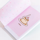 The interior of the book, showing off a "Pudeen" comic with Pusheen taking the shape of a Flan dessert. On the left page is multi-colored sprinkles print.