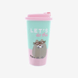 A pink and mint travel mug. The lid is pink. The mug is pink on the bottom and mint on top, with Pusheen in glasses drinking a dark beverage out of a white mug. Above Pusheen is the text "Let's do this" in white and pinkA plastic teal and pink travel mug with a pink lid with a stopper on it. The mug features a lineless illustration of Pusheen sitting upright, wearing square glasses and a coffee cup, the text ‘Let’s do this’ written above her. 