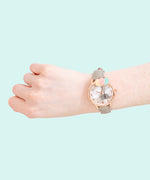 Model wearing the Pusheen Watch on their right hand in in front of a mint background. 