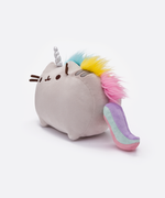 Quarter view of the Pusheenicorn plush, facing the left, standing in a whitespace. The mane starts behind Pusheen’s right ear, and runs down the middle of her back all the way to her tail. 