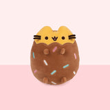 Front view of Chocolate Dipped Cookie Squisheen. Pusheen the Cat is shown in yellow with her classic eyes, mouth, and whiskers. The bottom portion of the plush is brown and has rainbow assortment of blue, green, white, and pink embroidered lines to look like sprinkles. 