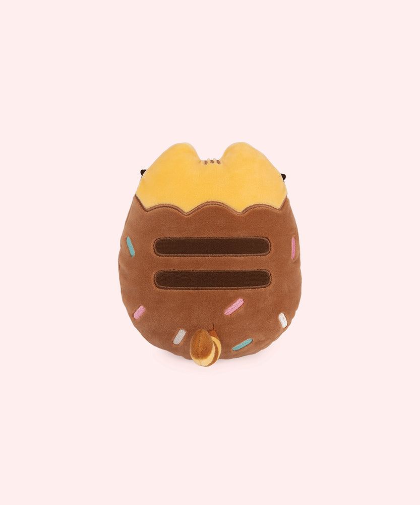 Back view of the plush shows Pusheen’s classic lines ar her back with her striped tail that is yellow and brown on this Chocolate Dipped Cookie Squisheen. 