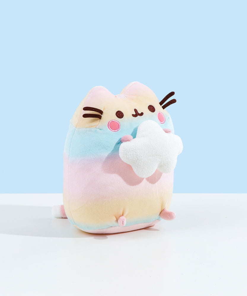 A quarter profile of the Rainbow Pusheen plush facing the right. She almost looks like a little Easter egg. Pusheen's paws are a light pastel pink. The pink in Pusheen's blush is a much more saturated pink.