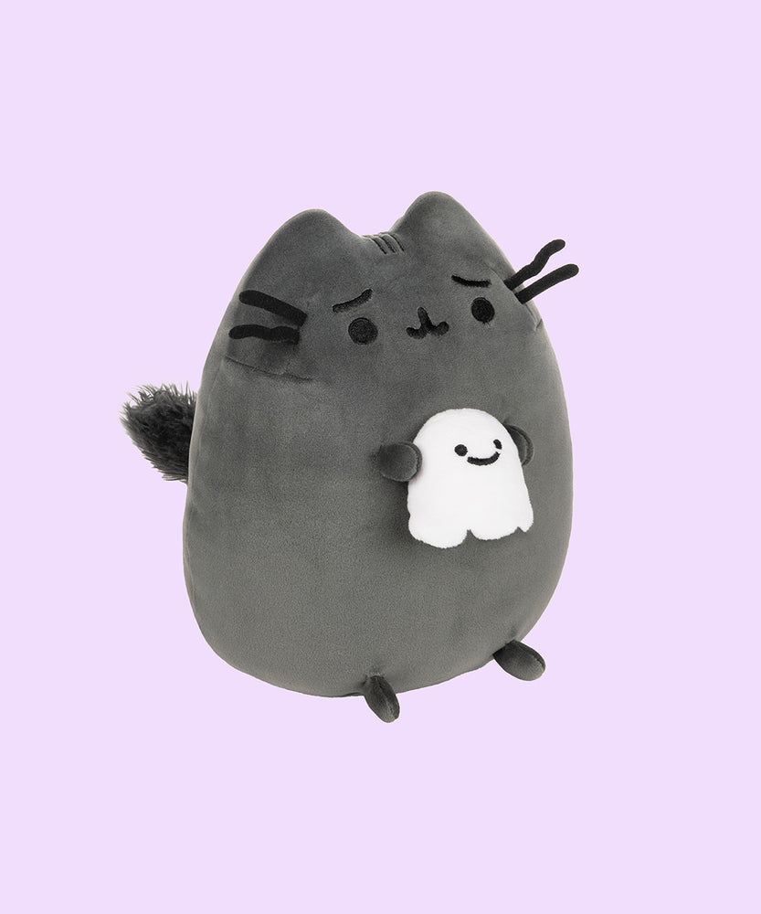 Right quarter view of the Scaredy Cat Squisheen shows Pusheen the Cat holding a light white ghost in her front paws that has a smile on its face. From this view, Pusheen’s puffed out tail can be seen coming out of her back. 
