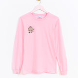 Front view of the pink long-sleeve t-shirt. The pink tee hangs on a light pink hanger in front of a white background. 