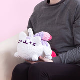 The Super Pusheenicorn crocheted plush being held in a lap