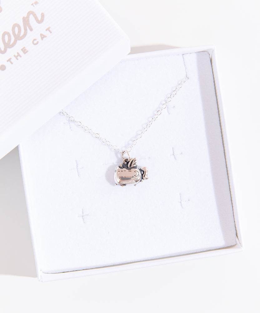 A small white square jewelry box with the lid removed and placed on the top left corner of the box holding the Silver Super Pusheenicorn Charm Necklace. The jewelry lid features the Pusheen the Cat logo printed in silver.