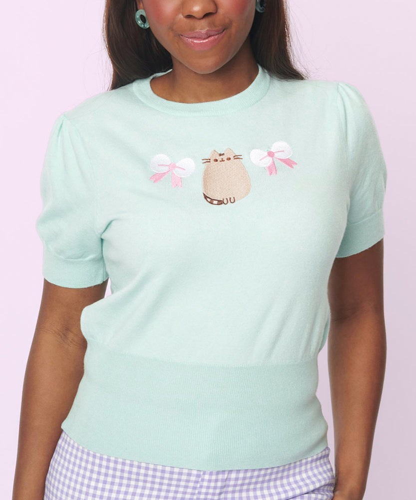 Front view of the mint green sweater. The short-sleeve sweater has ribbed detailing at the sleeve and bottom hems.