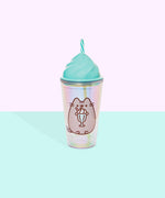 Front view of the Pusheen Whipped Tumbler. The iridescent tumbler cup features a printed Pusheen enjoying a vanilla milkshake out of a mint green cup with a red and white stripped straw. The top of the tumbler is a light green and mimics the shape of whipped topping. Out of the top of the tumbler is a rotating striped clear and mint green straw.