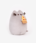 Quarter view of the Pizza Pusheen Plush facing the right in front of a white background. The pizza slice I a yellow plush triangle with a light brown crust and three red dots of pepperoni. The pizza slice is pointing up towards Pusheen’s mouth.